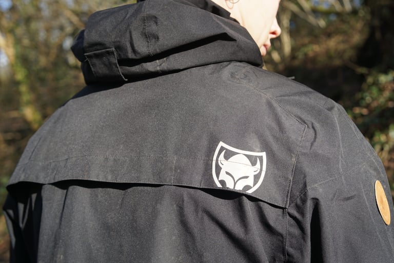 Rear of the TSG Drop Rain Jacket with the reflective logo on the vented panel across the shoulders.
