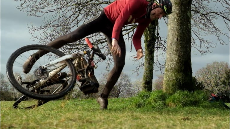 Will Jones tumbles off his cyclo-cross bike on grass beside trees while testing the Ritchey MegaBite at low pressure.