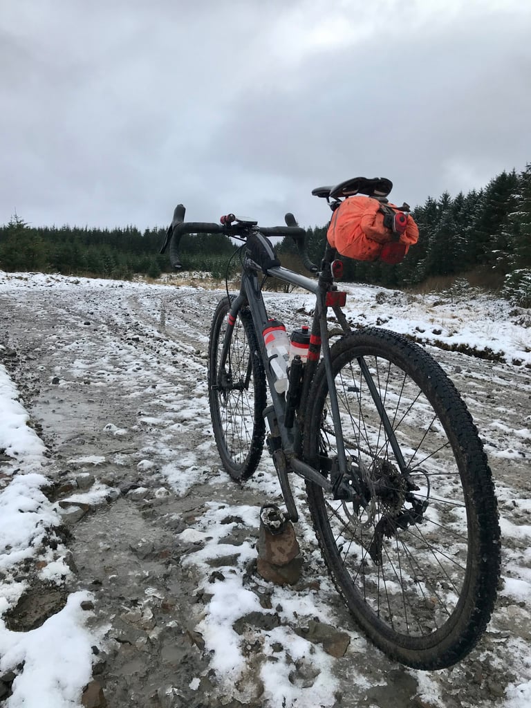 Loaded gravel bike on a snowy, muddy forestry track on the sub-zero day-four Festive 500 ride in South Wales.