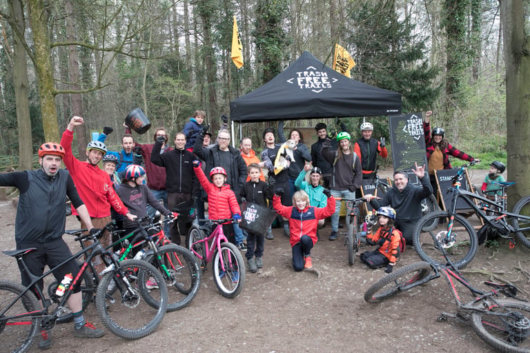 Trash Free Trails volunteers and children with bikes gather under a branded tent at an Ashton Court litter pick.