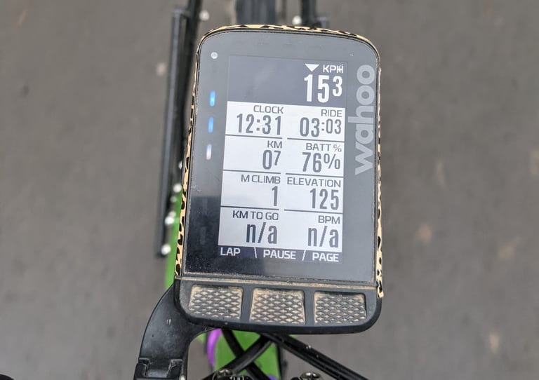 Wahoo ELEMNT ROAM ride data page in a leopard-print wrap, with the side LEDs lit beside the screen.