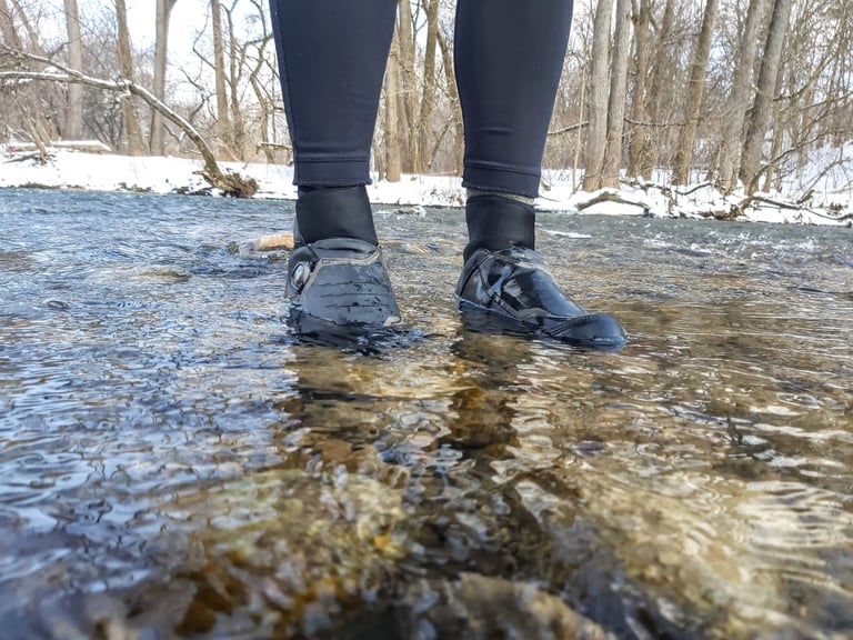 Rider stands in Shimano MW7 boots in a shallow flowing river in Ontario, Canada, to test how waterproof they are.