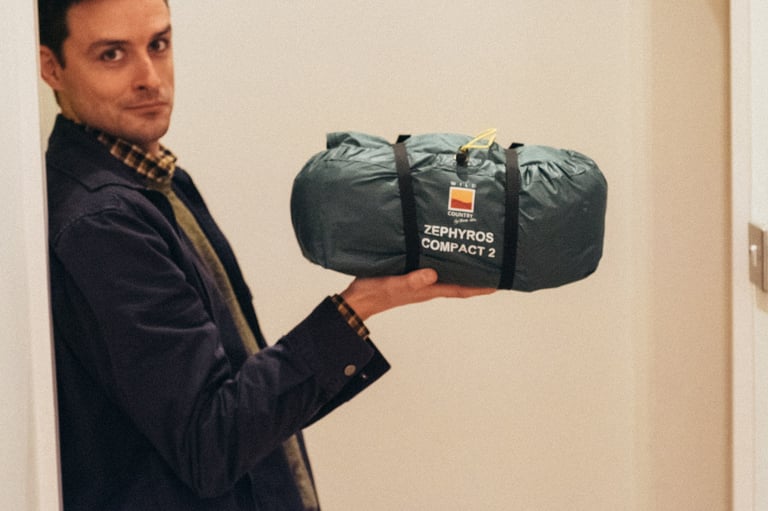 Tester holds the packed Wild Country Zephyros Compact 2 in one hand, showing how small the tent bag is.
