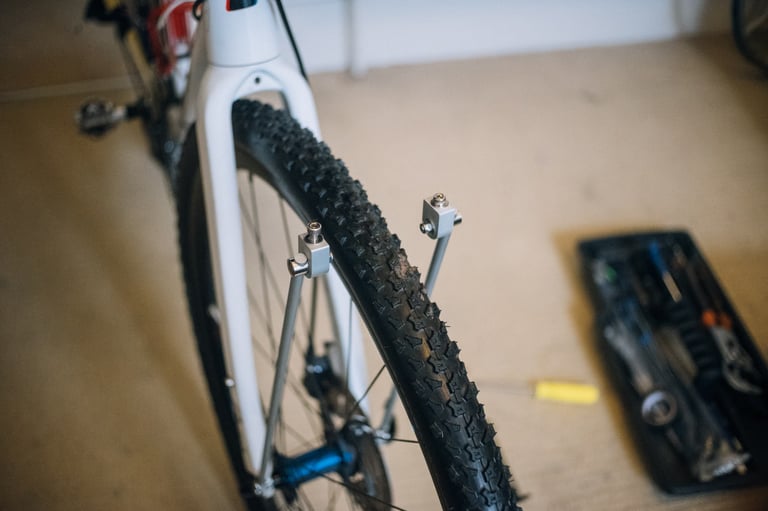 Two Tubus rack struts clamped to the front fork legs, rising either side of the front tyre.