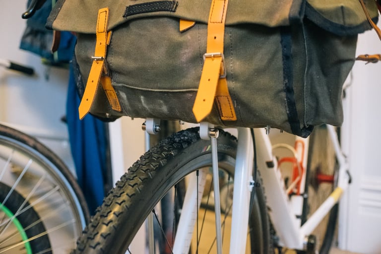 Canvas handlebar bag sitting on the finished DIY support, with struts running down to the front fork.
