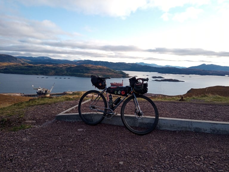 Touring bike with a frame bag parked at a viewpoint above a sea loch on the second day of the Scotland ride.