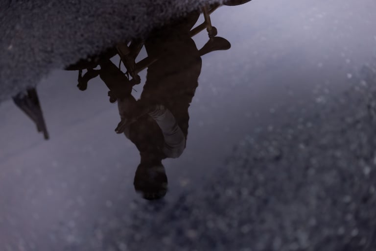 Upside-down reflection of a cyclist in a wet road puddle, from The Tipping Point winter short film.