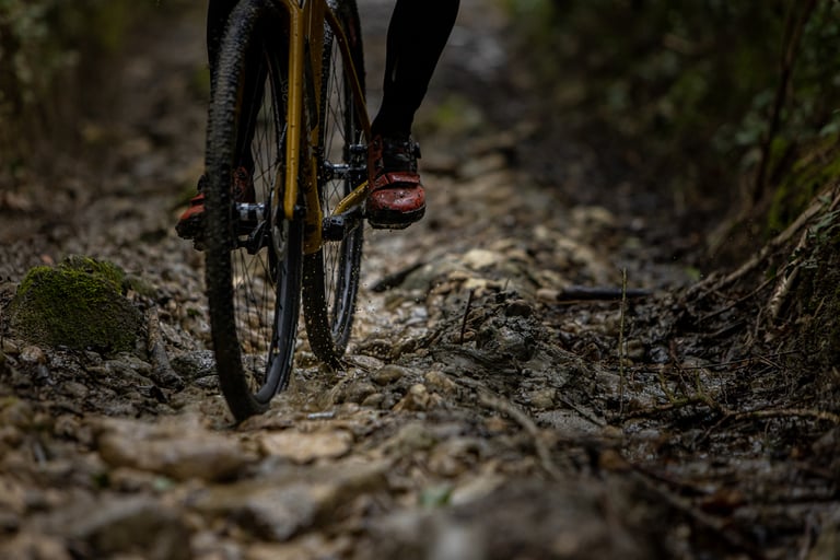 Rider's wheel and muddy shoes on a rocky limestone stream-bed track near Bristol, filmed for The Tipping Point.