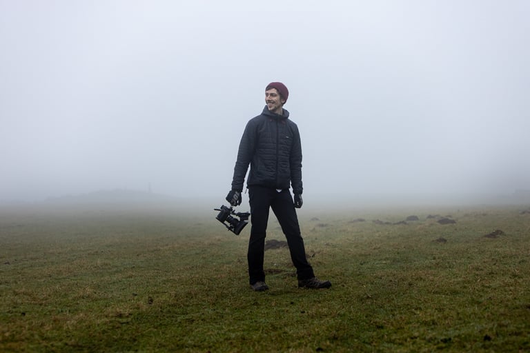 Co-director and cinematographer Dom John holds a gimbal camera rig in a misty field during The Tipping Point shoot.