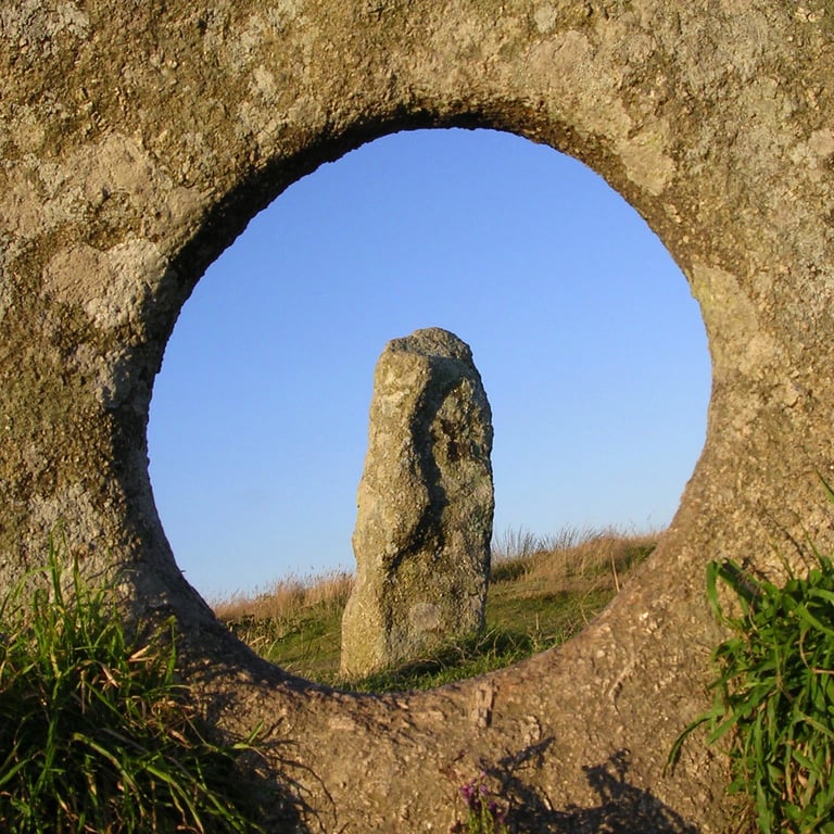Mên-an-Tol, the holed stone in Cornwall, with a standing stone seen through the hole, on the West Kernow Way.