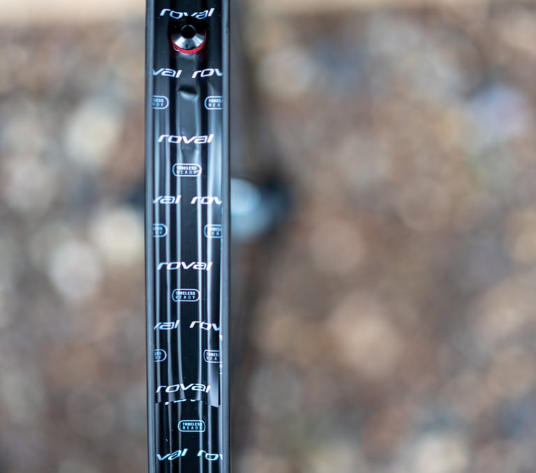 Close-up of a Roval Rapide C38 carbon rim showing tubeless-ready labels, valve and rim tape.
