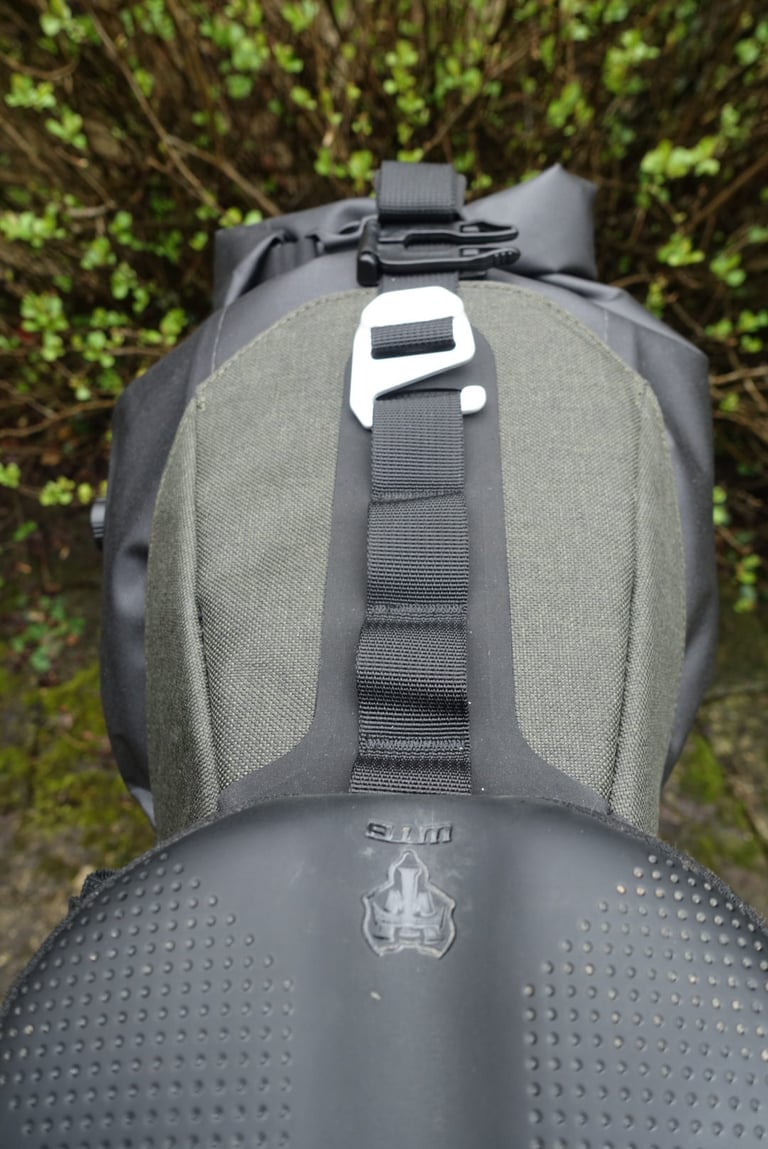 Looking down on the Brooks Scape Seat Bag from the saddle, with daisy chain webbing and an aluminium hook over the holster.