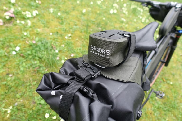 Small Brooks Scape Saddle Pocket Bag strapped on top of the larger seat bag, behind the saddle.