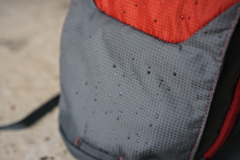 Water beading on the grey and red ripstop fabric of the EVOC Ride 12L.