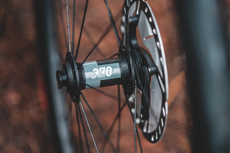 DT Swiss 370 hub and disc rotor on a Roval Rapide C38 wheel, with water droplets on the black spokes.