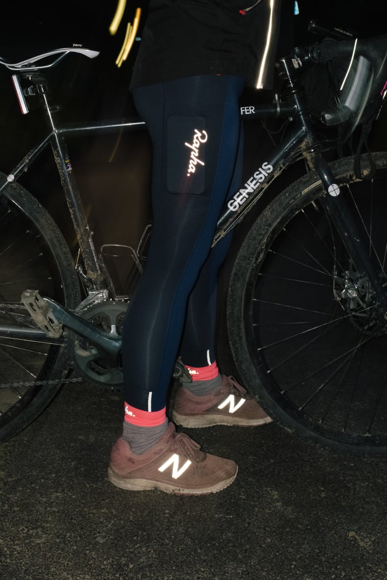 Rapha All Day Leggings at night, with the reflective logo, pink cuffs and shoe details lit by flash beside a Genesis bike.