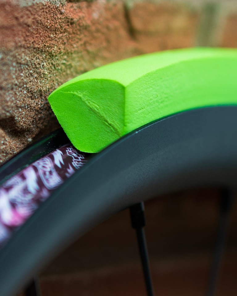 Vittoria Air-Liner Gravel foam insert sitting on a wheel rim, seen end-on against a brick wall.