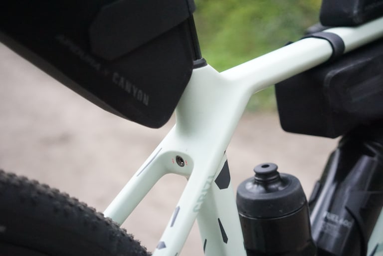Integrated seat clamp bolt low on the Canyon Grizl's seat tube, below the Apidura x Canyon saddle pack.