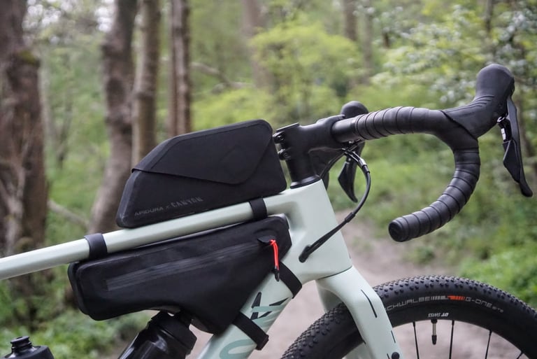 Apidura x Canyon bolt-on top tube bag and frame pack on the Grizl, with the drop handlebar behind.