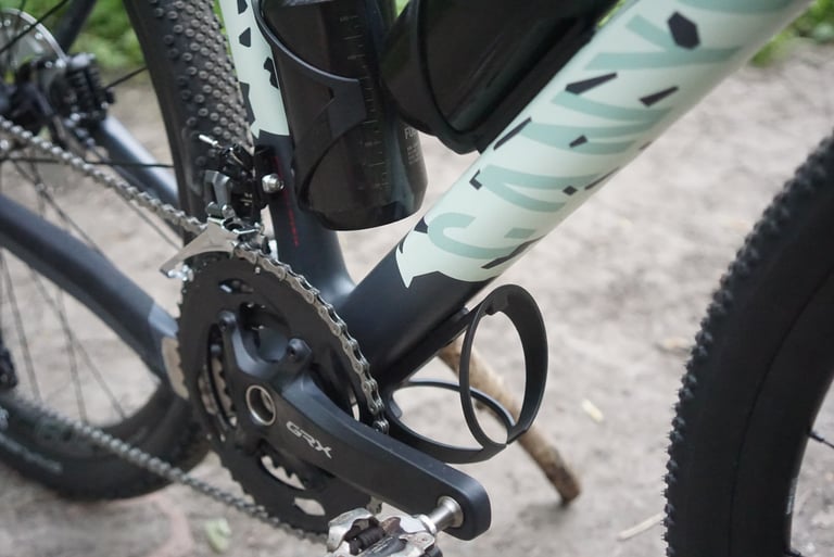 Empty bottle cage bolted under the Canyon Grizl's down tube, just ahead of the Shimano GRX chainset.