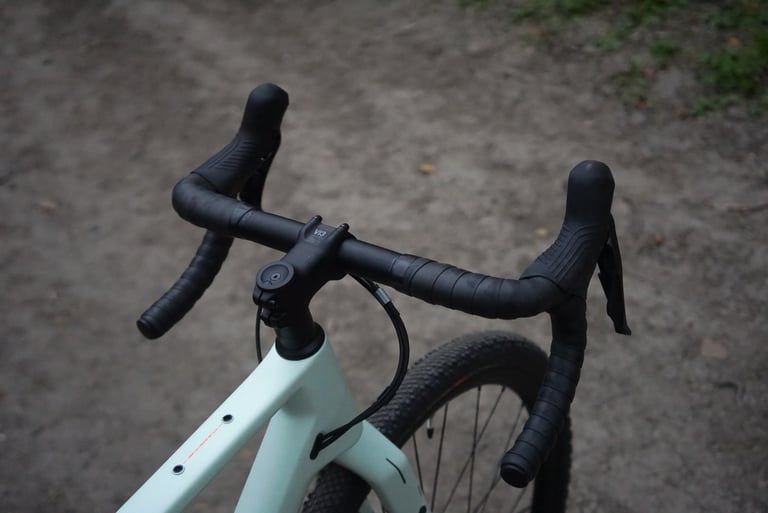 Canyon Grizl conventional round handlebar and Shimano GRX brake levers, seen from above on a dirt track.