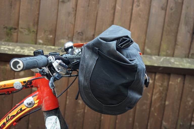 Open-topped mesh side pocket on the Ortlieb Handlebar Pack QR, fitted to a flat-bar mountain bike.