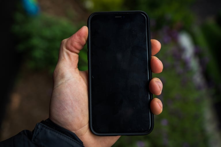 Front of an iPhone 11 Pro in a Fidlock VACUUM case held in one hand, screen off, with no visible wear to the case.