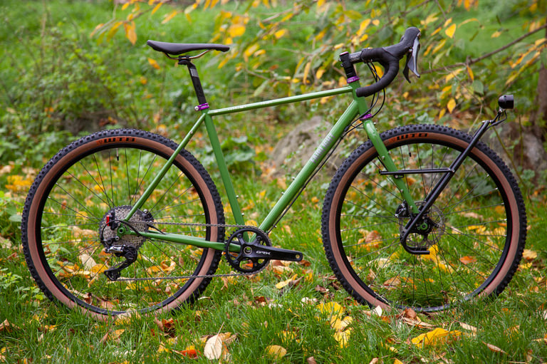 Green Fairlight Faran 2 with WTB tyres, GRX 1X drivetrain and dynamo light, side view in autumn leaves.