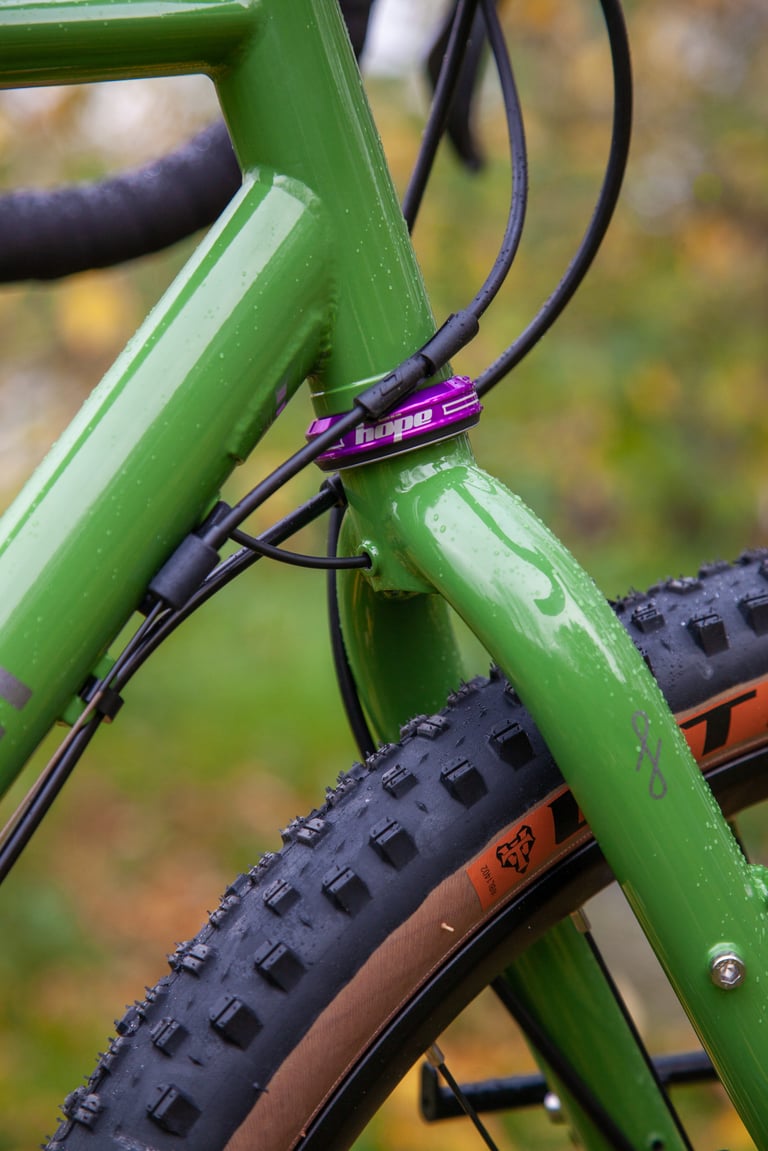 Fairlight Faran 2 head tube detail with purple Hope headset, internal cable routing and a tan-wall WTB tyre.
