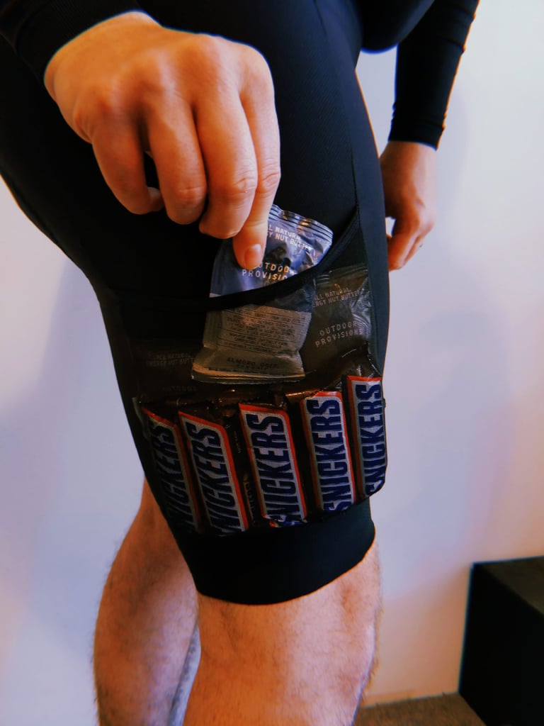 Santini Gravel Bib mesh thigh pocket packed with a row of Snickers bars and energy nut butter sachets.