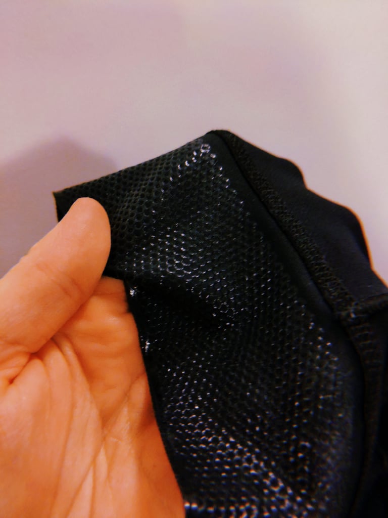 Inside of the Santini Gravel Bib leg cuff, showing the silicone dot gripper held open between finger and thumb.