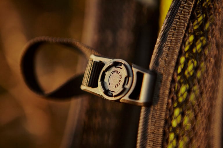 Close-up of the Camelbak Mule Pro chest strap magnet marked Twist to open, against a mesh strap.