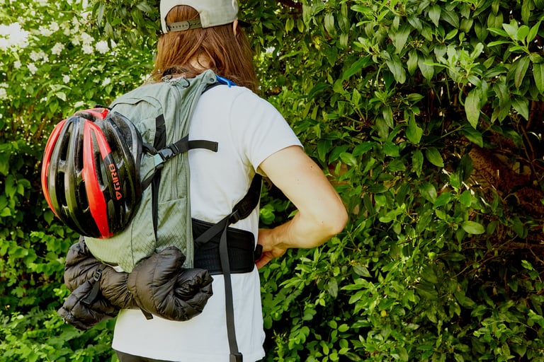 Rider seen from behind wearing the Camelbak Mule Pro with a helmet and down jacket strapped to the outside.