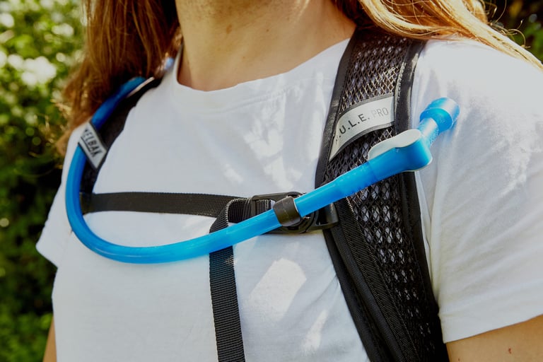 Camelbak Mule Pro hose held by the magnetic chest strap buckle across a rider's chest.