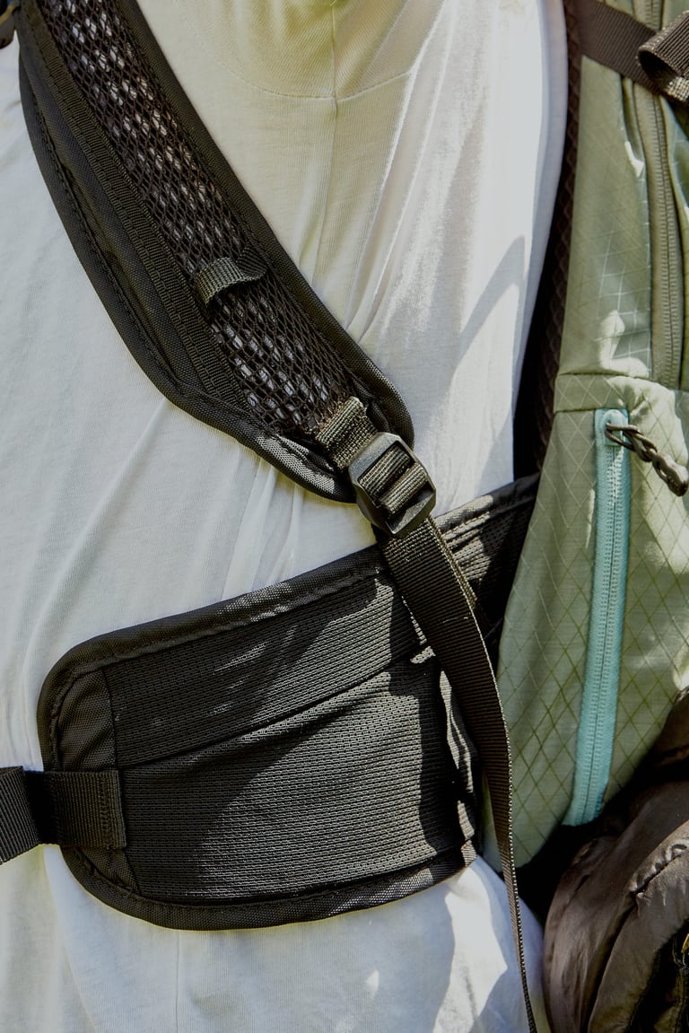 Padded mesh shoulder strap and hip belt panel of the Camelbak Mule Pro, with a zipped side pocket beside.