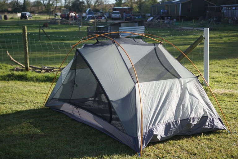 Alpkit Jaran 2 inner tent pitched on grass without its flysheet, showing mesh panels and the orange pole.