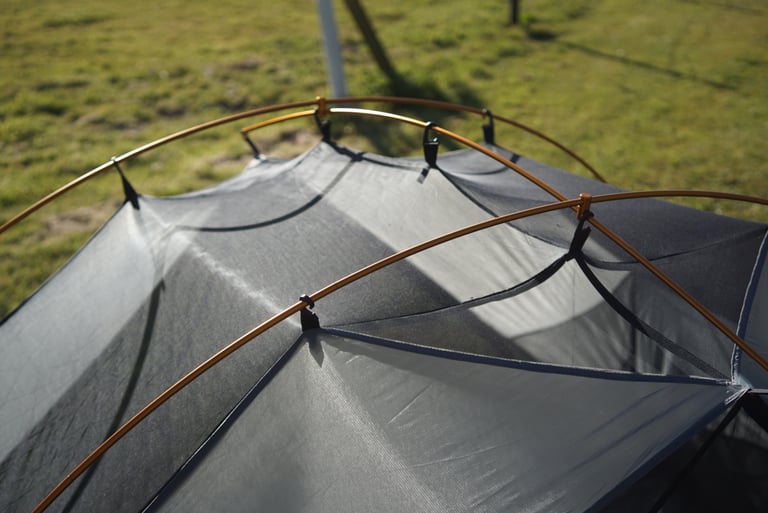Close-up of the Jaran 2's single orange pole arching over the grey inner tent, held by clips.