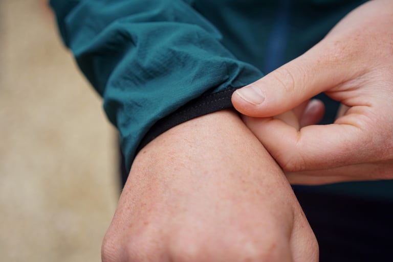 Close-up of the black elasticated cuff on the sleeve of the Velocio Ultralight Hooded Jacket.