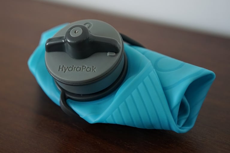 Close-up of the grey twist-to-open HydraPak lid on a collapsed blue Flux 1L soft bottle.