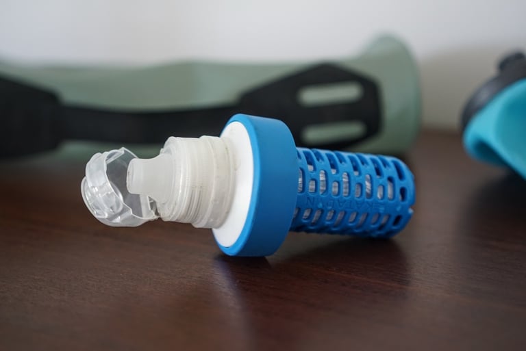 Katadyn BeFree replaceable filter cartridge in blue with its clear drinking nozzle, lying on a table.