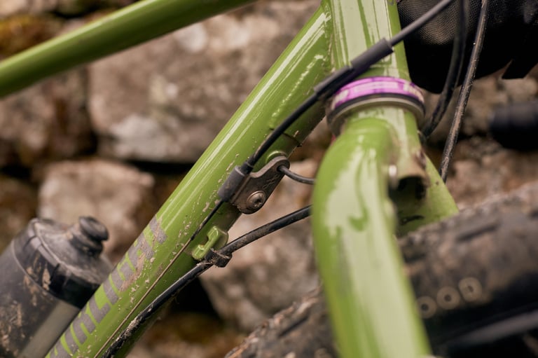 Close-up of the Fairlight Faran 2 downtube cable guide and dynamo wire routing below a purple Hope headset.