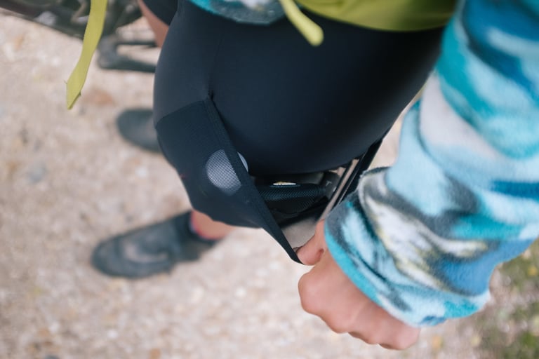 Close-up of a hand pulling open the mesh side pocket on Specialized RBX Adventure SWAT bib shorts.