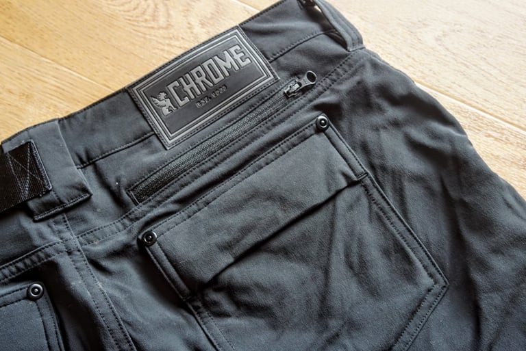 Rear of the Chrome Anza shorts showing the flap-top back pocket, zipped pocket and Chrome waistband patch.