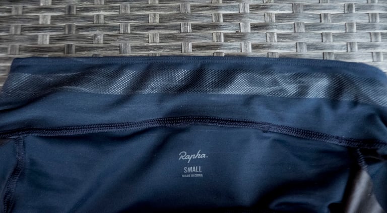 Inside of the wide waistband on Rapha Core Cargo shorts, with mesh panel, stitching and a size small label.