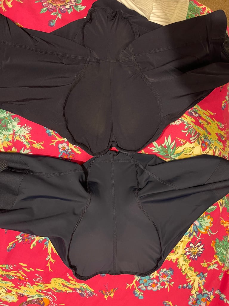Rapha Cargo Bib shorts and Core Cargo shorts laid inside out on a floral bedspread to compare chamois widths.