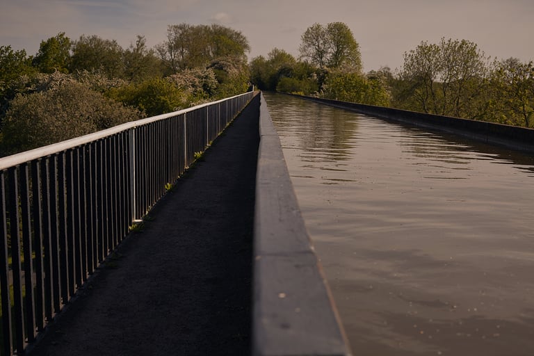 Towpath along a railed aqueduct on the Grand Union Canal in Warwickshire, the flat route south past Birmingham.