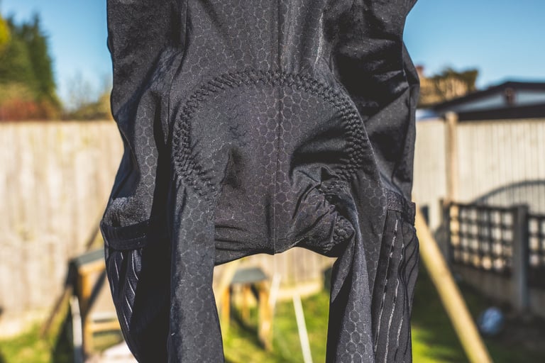 Lusso Adventure bib shorts hung outdoors, the honeycomb fabric and chamois outline showing through from the outside.