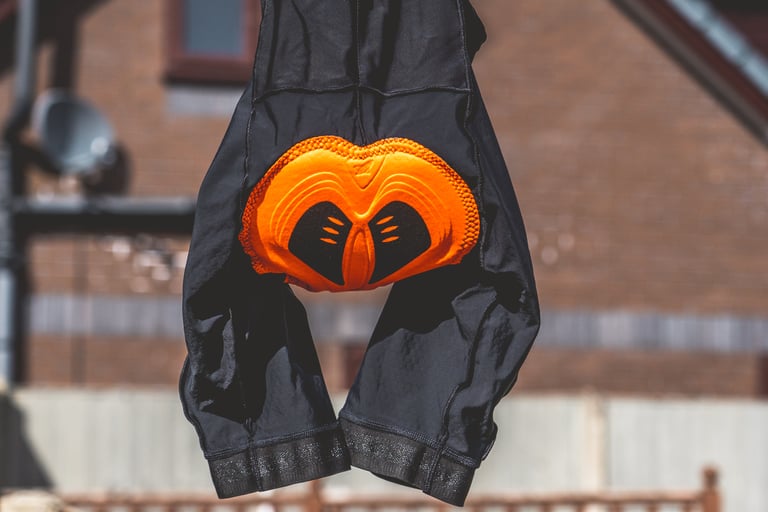 Lusso Adventure bib shorts hung up with the orange endurance chamois pad facing the camera.