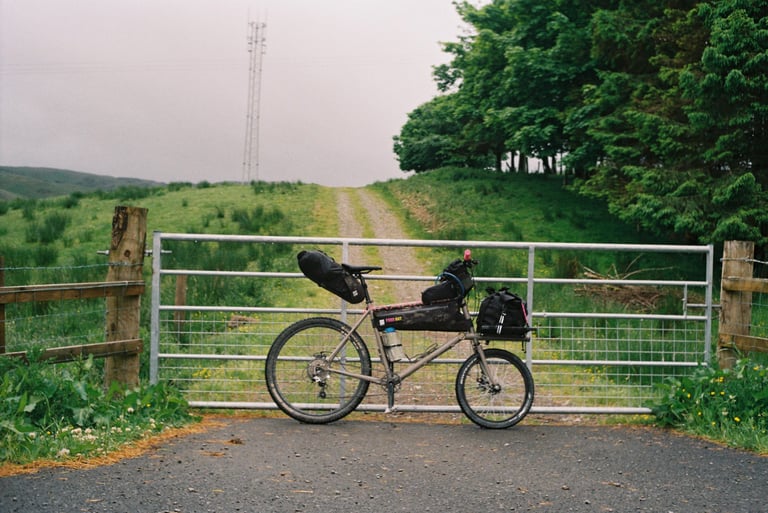 Rothair mini cargo bike with frame bag, seatpack and front carry platform parked at a field gate on the Pennine Rally.