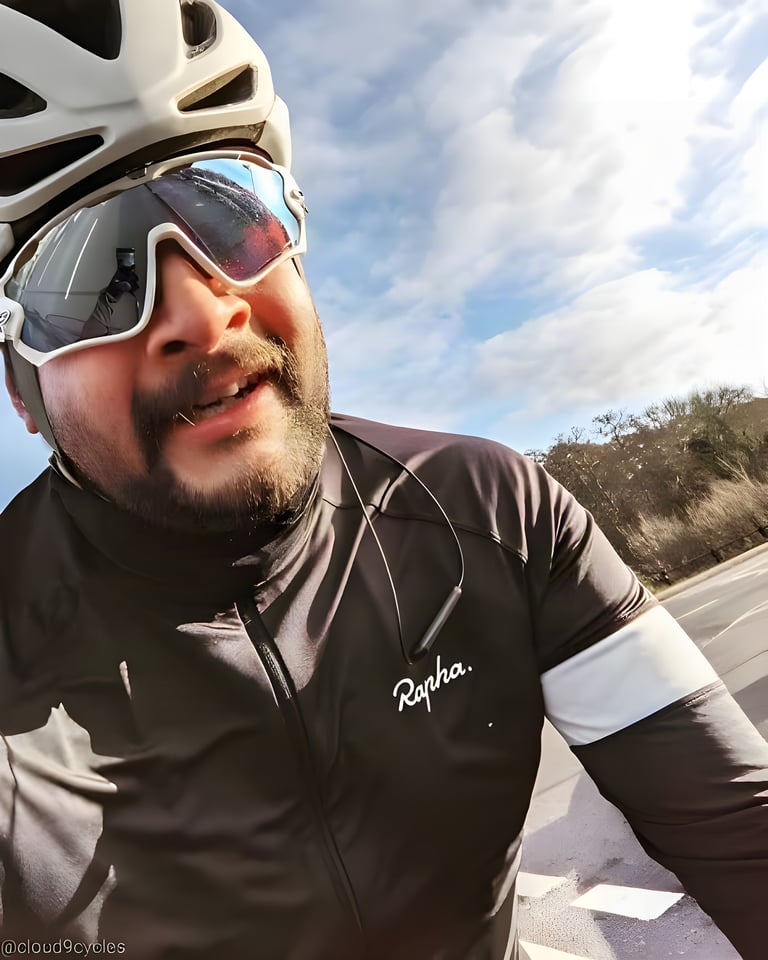 Ultra Distance Scholarship recipient Nathan Patel grins in a selfie in a helmet and mirrored glasses on a sunny road.